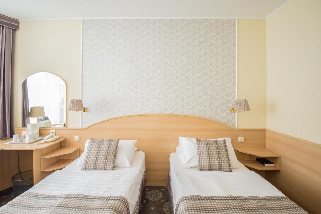 布达佩斯猎户座城堡花园酒店的酒店客房配有两张床和一张书桌