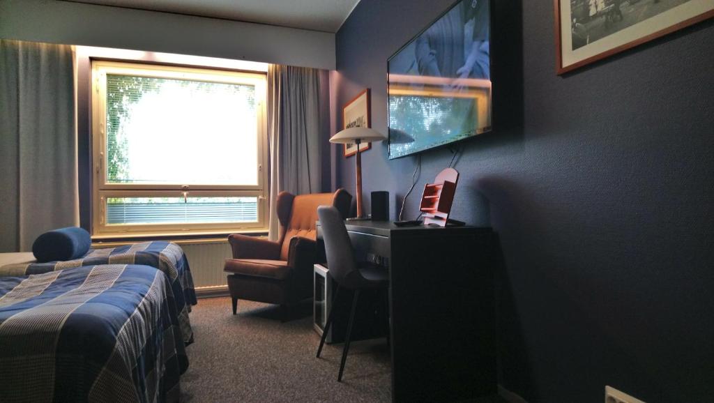 图尔库West Side Hotel的酒店客房设有一张桌子、一张床和一个窗户。