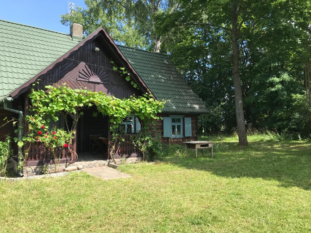 SzlinokiemieSuwalskie siedlisko的有一所小房子,上面有一堆葡萄藤
