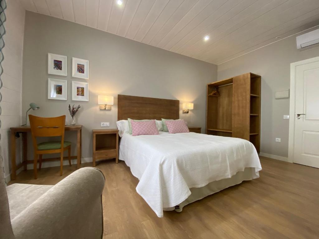 孔苏埃格拉Azafrán Consuegra的卧室配有一张白色大床和一把椅子