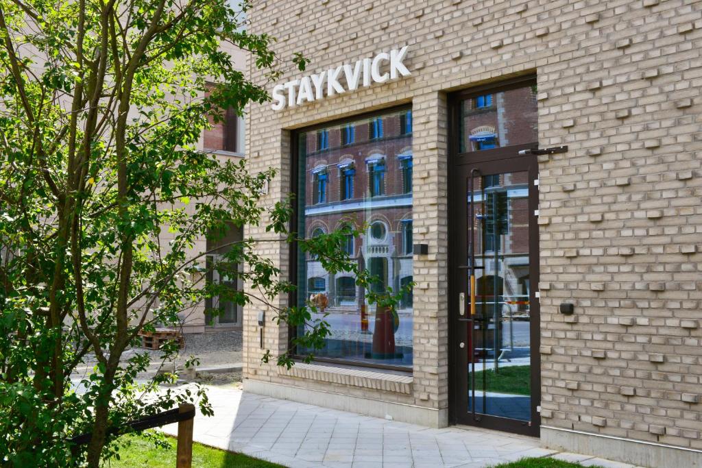 赫尔辛堡Staykvick Boutique Hostel的砖楼前有标志的商店