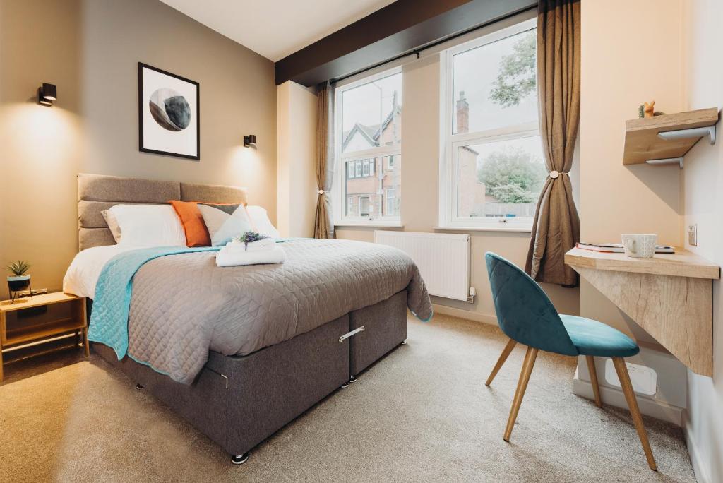 塔姆沃思Victoria Apartments Tamworth的一间卧室配有一张床、一张书桌和一个窗户。