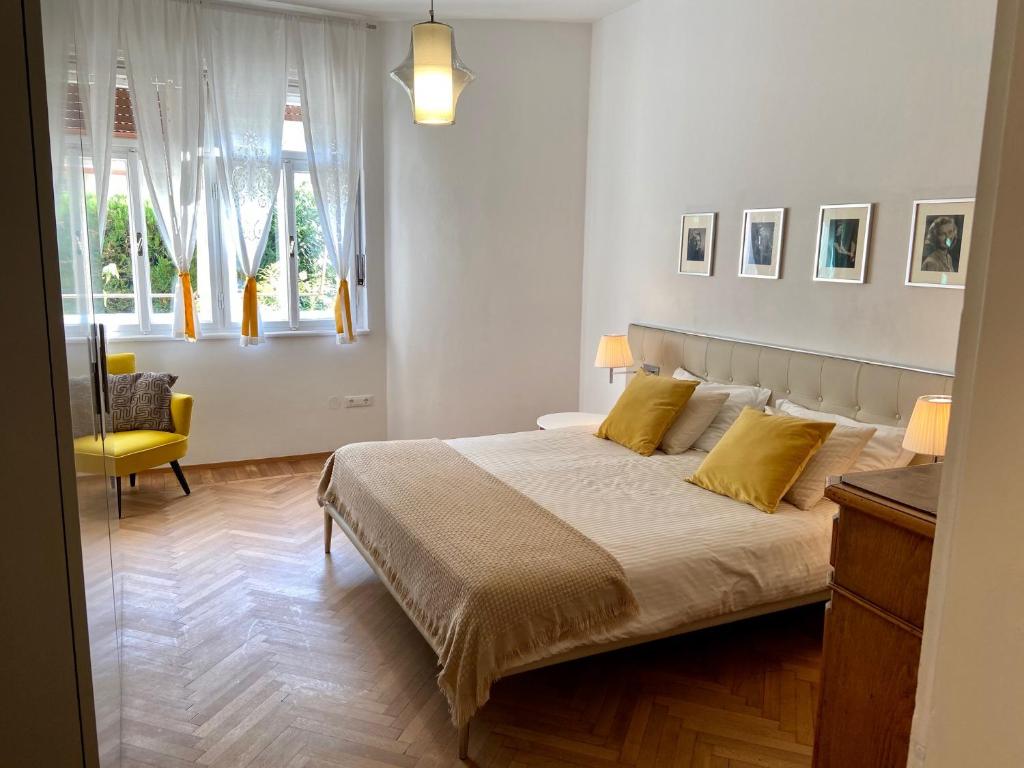 梅拉诺Delightful Villa Rina的一间卧室配有一张带黄色枕头的大床