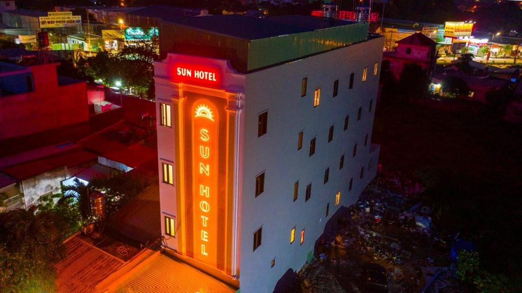 土龙木市SUN HOTEL的一座晚上有 ⁇ 虹灯标志的建筑