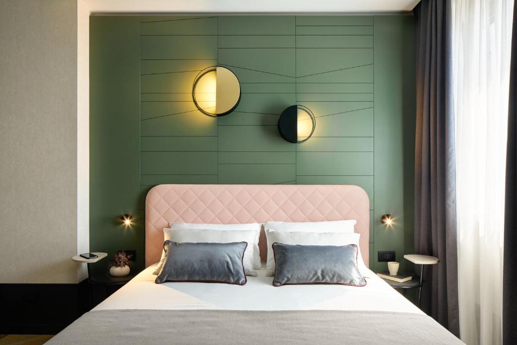 皮亚韦河畔圣多纳Hotel Forte del 48的一间卧室配有一张带粉红色床头板的床和两个枕头