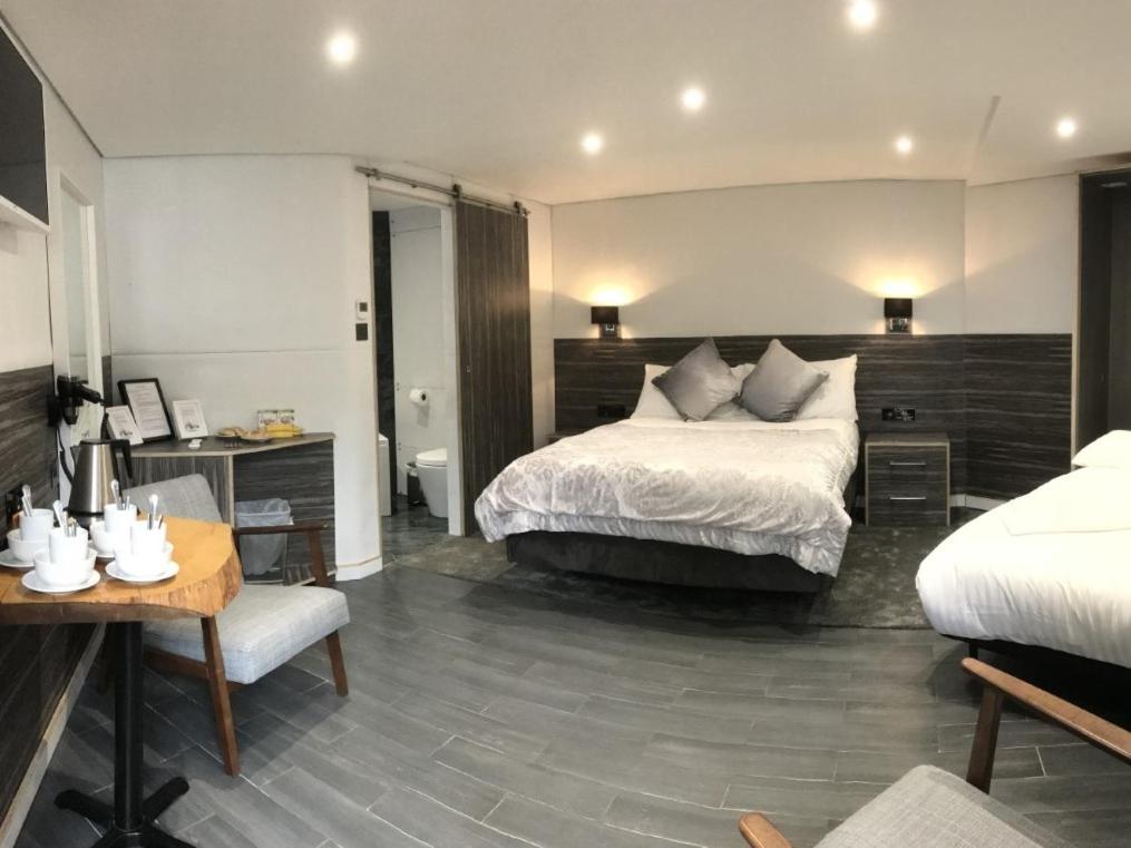 希灵登水畔运河别墅酒店的酒店客房配有一张床、一张桌子、一张床铺和一张桌子。