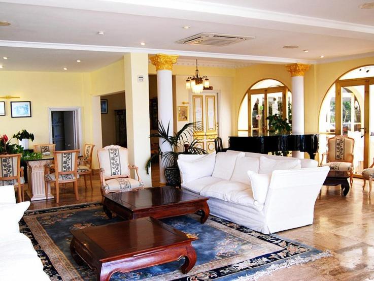 卡沃内拉斯Hotel El Dorado的客厅配有白色的沙发和桌子