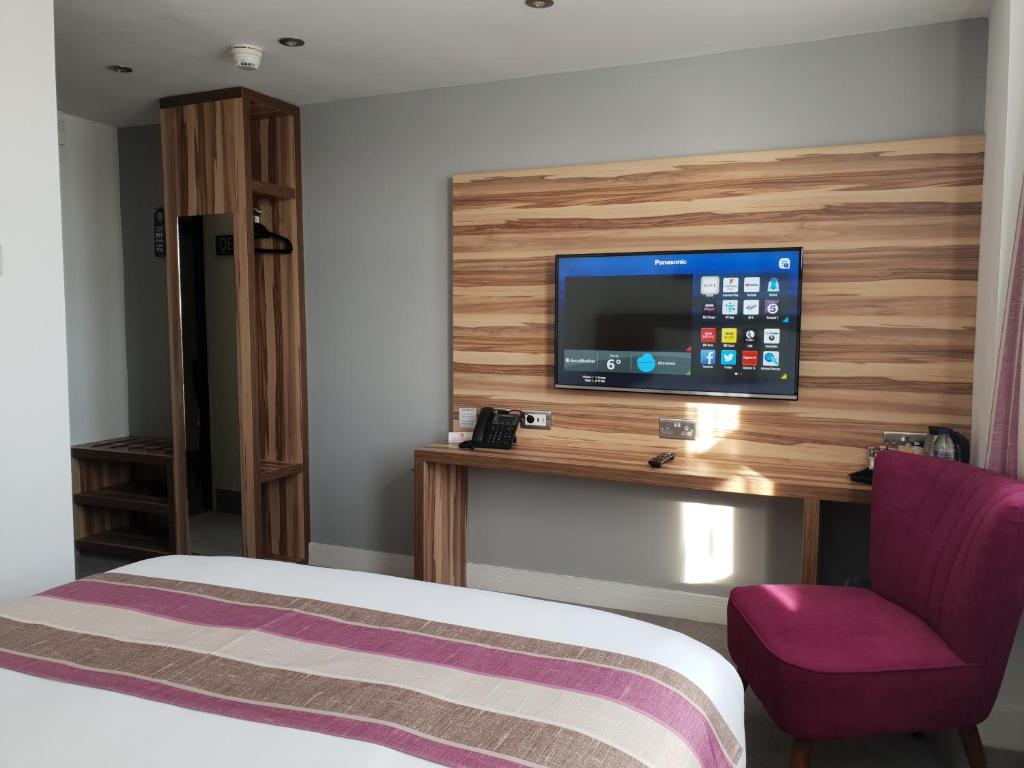 巴罗弗内斯Escape Hotel的一间酒店客房,配有一张床和一台墙上的电视