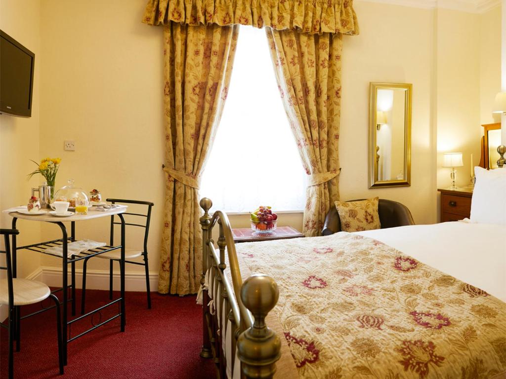 法利Filey Grange的酒店客房设有床、桌子和窗户。