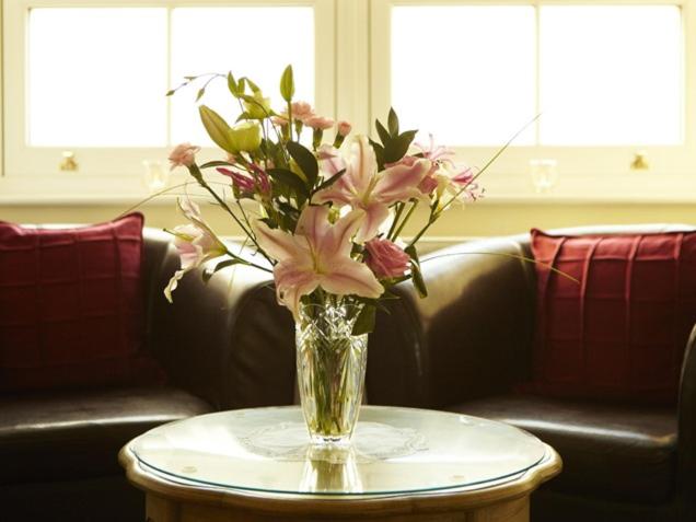 法利Filey Grange Guest House的花瓶坐在桌子上