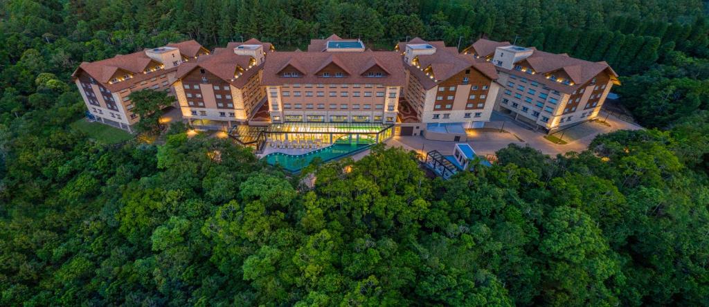 格拉玛多Wyndham Gramado Termas Resort & Spa的树林中一座大建筑的空中景观
