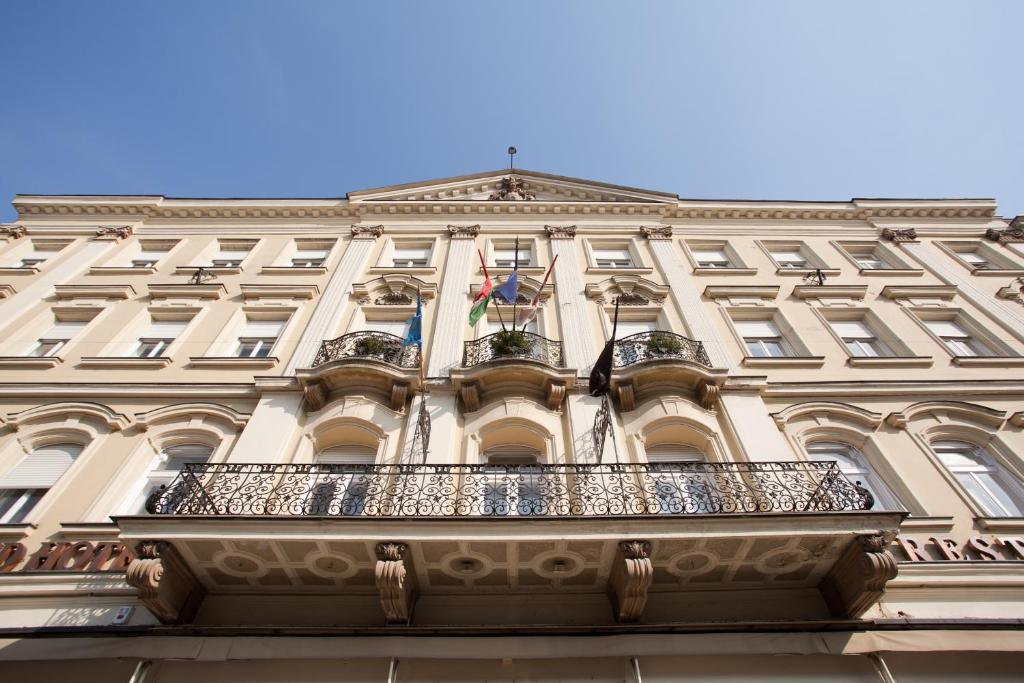 索普隆潘诺尼亚酒店 的一座带两面旗的阳台的建筑
