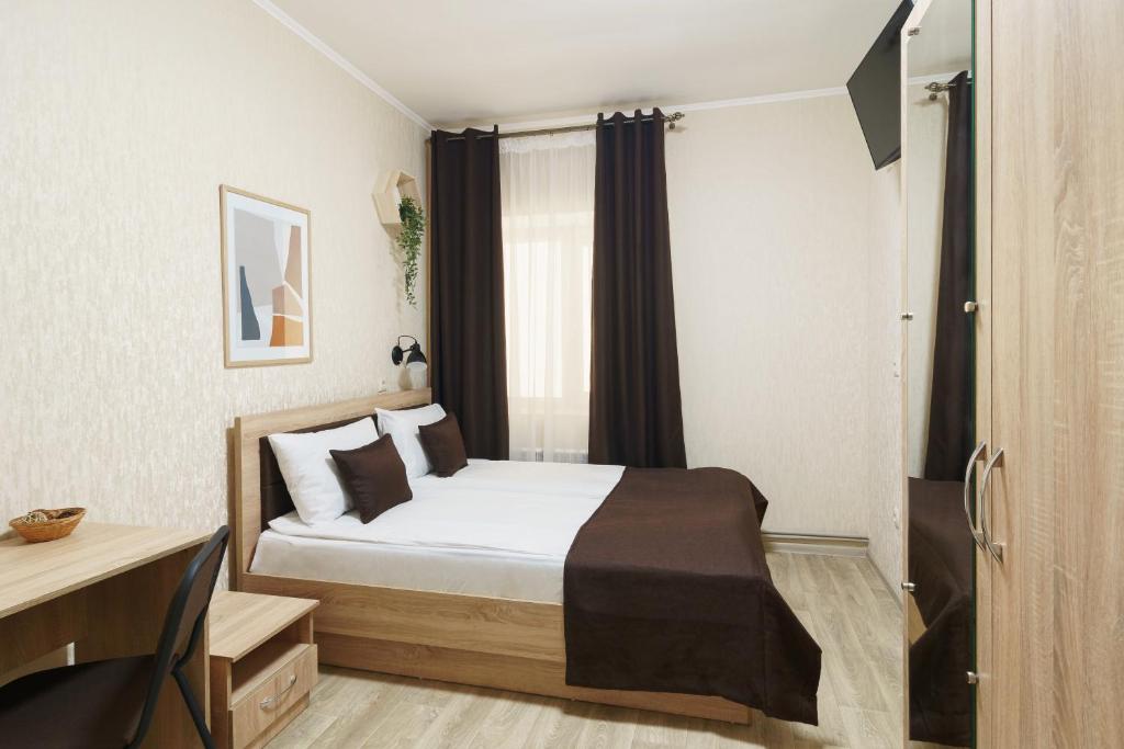 哈尔科夫Отель Южный Двор的一间卧室配有一张带白色床单的床和一扇窗户。