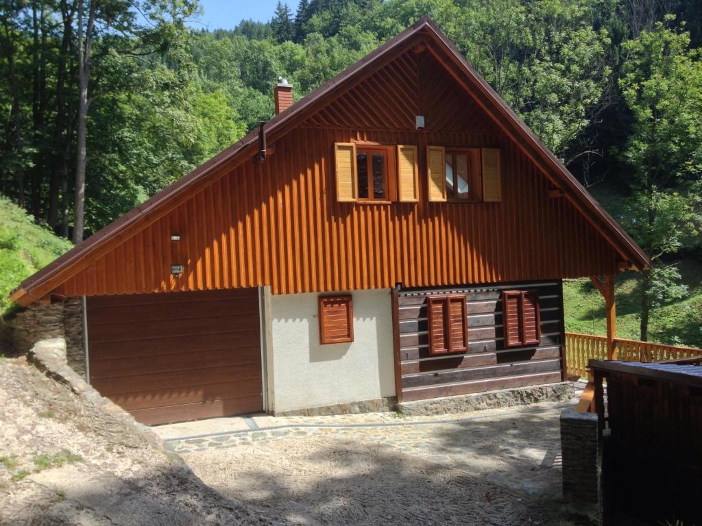 捷克布杰约维采棒棒小屋的一间设有棕色屋顶和车库的小房子