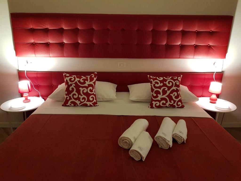 维罗纳Verona Romeo's Eye的一张带红色床头板的床和两双毛巾
