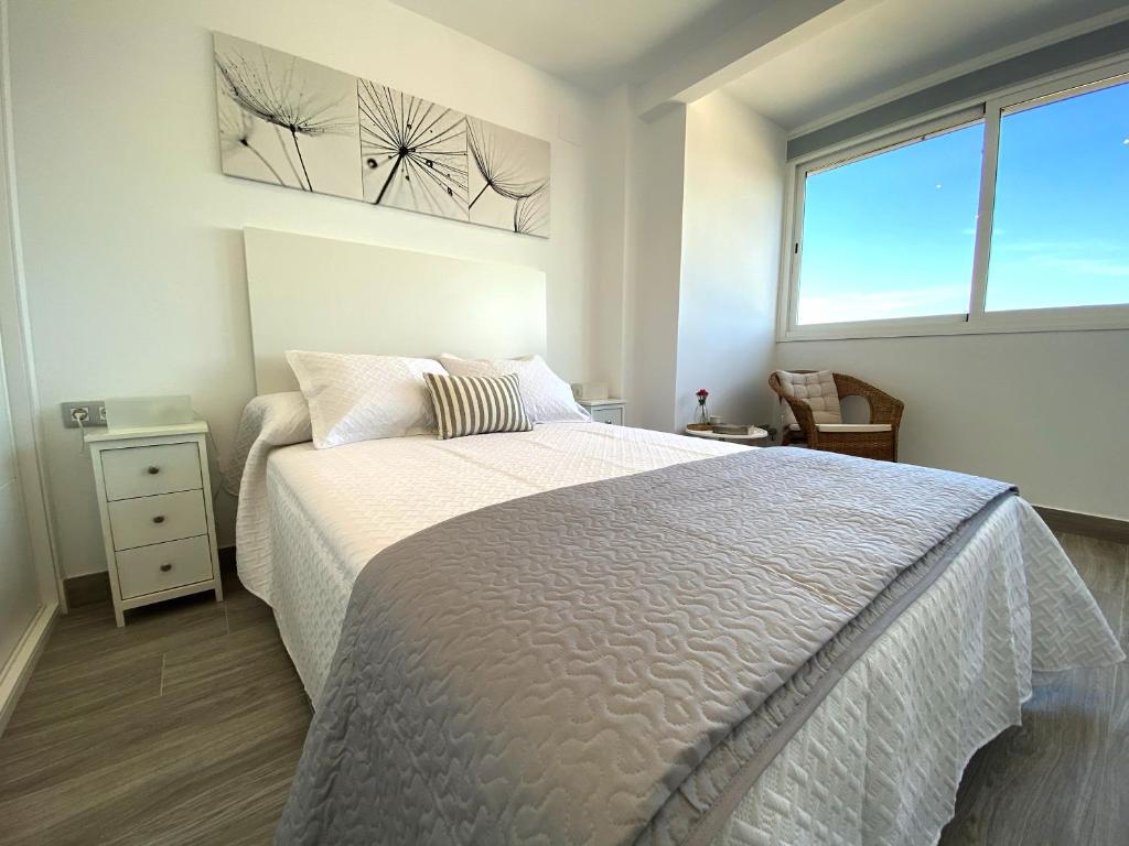 塞维利亚Residencial Santa Justa - Vacacional Sevilla的一间卧室设有一张大床和一个窗户。