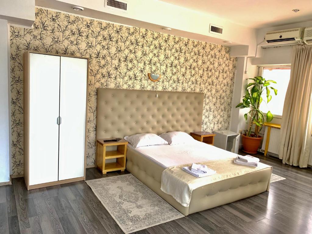 布加勒斯特有趣时光酒店的一间卧室设有一张大床和一面墙