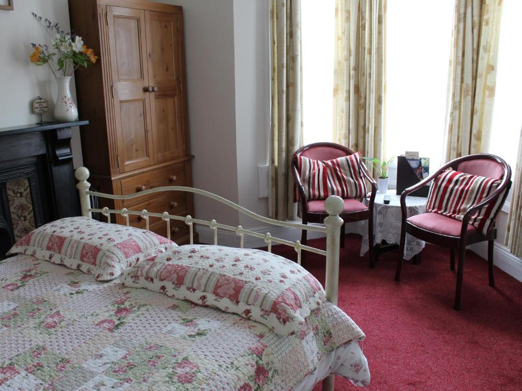 巴斯White Guest House的一间卧室配有一张床和两把椅子