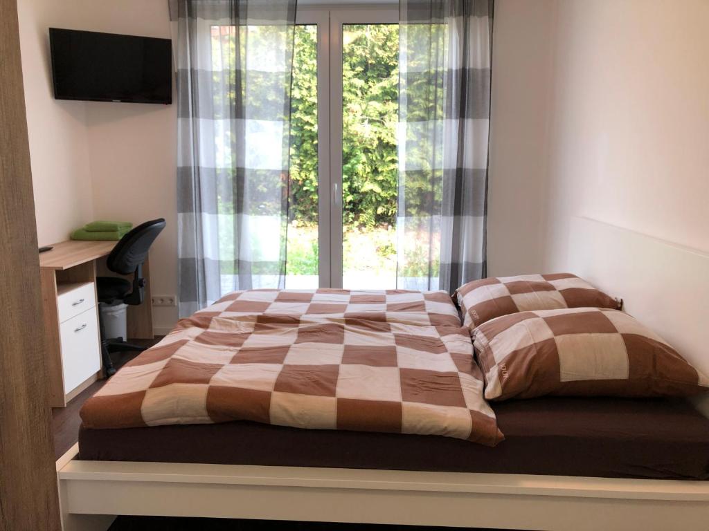 帕德博恩Gästehaus Witteborg的一间卧室配有一张带窗户的床和一张书桌
