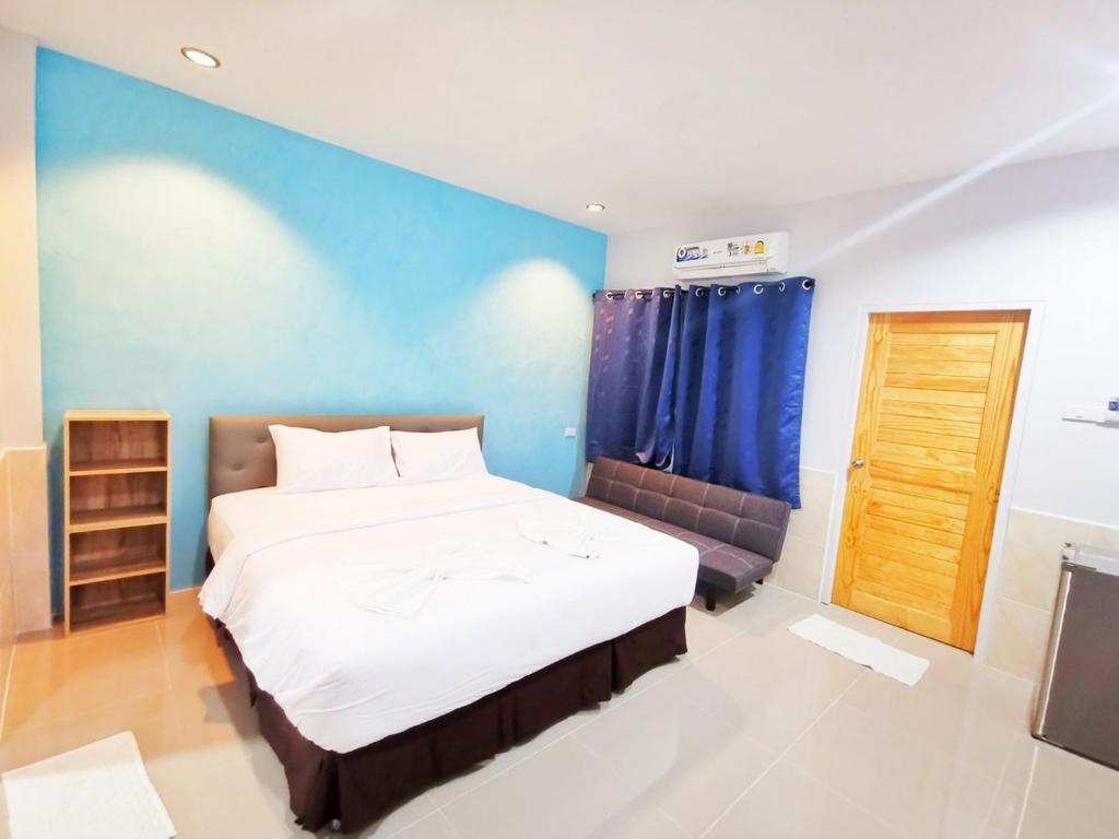 梭桃邑ลิตเติ้ล ฮิลล์ สัตหีบ รีสอร์ท ( Little Hill Sattahip Resort )的一间卧室设有一张大床和蓝色的墙壁