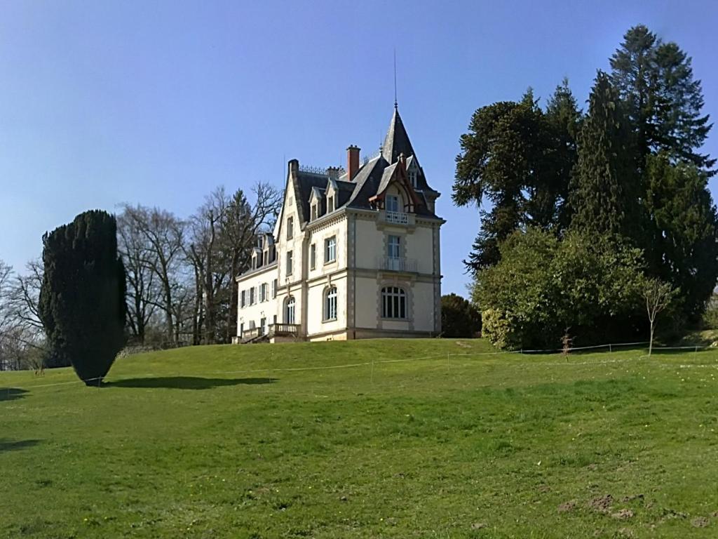 Bonnac-la-Côte圣安托尼城堡酒店的绿色田野顶部的白色大房子