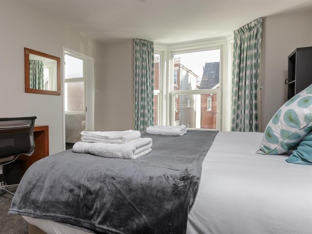 朴次茅斯Blue Star House的一间卧室配有一张大床和毛巾
