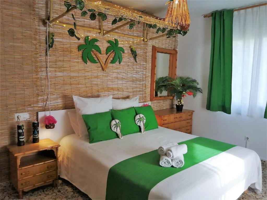 内尔哈Wonder Rooms Nerja Guest House的卧室配有绿色和白色的床和2条毛巾