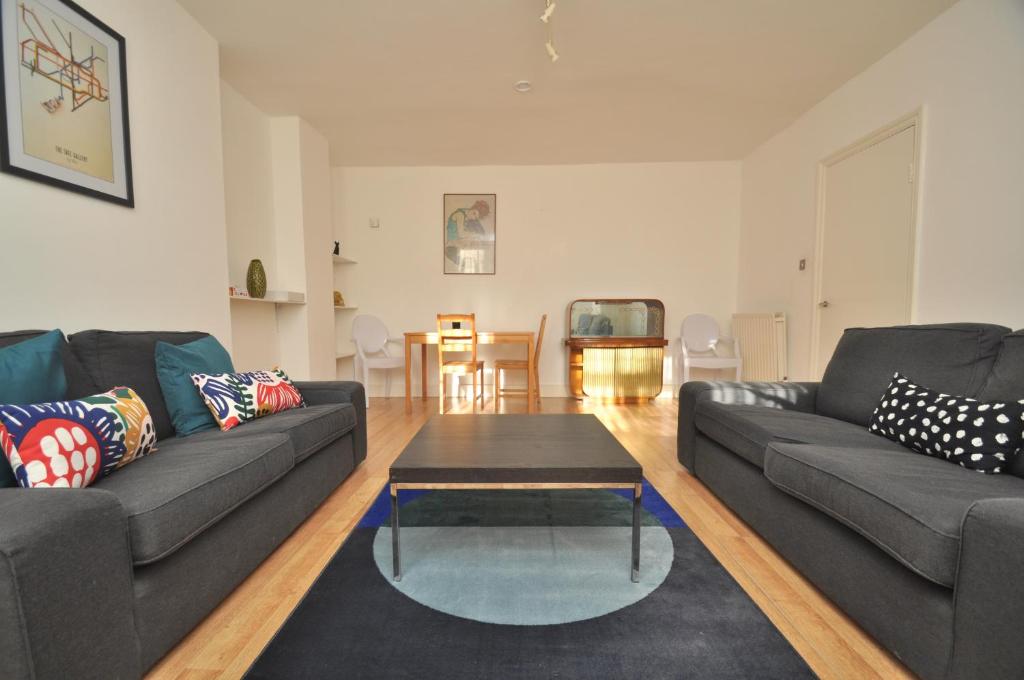 伦敦Large Garden flat in the heart of Islington的客厅配有两张沙发和一张咖啡桌