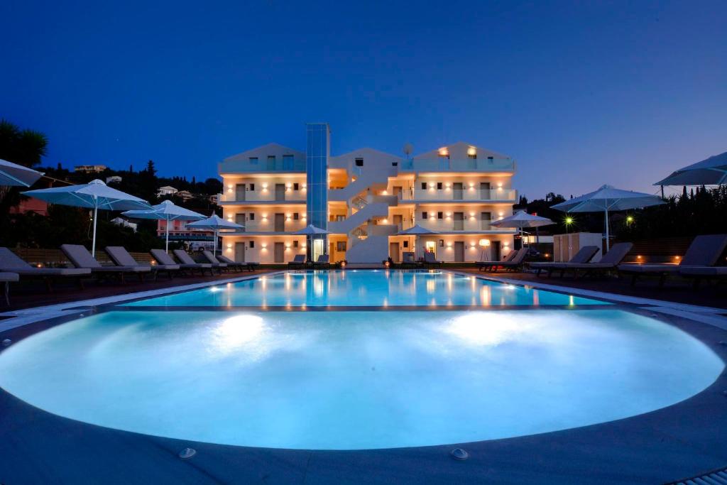 (( Agía Eleoúsa ))V Luxury Suites的晚上在酒店前面的大型游泳池