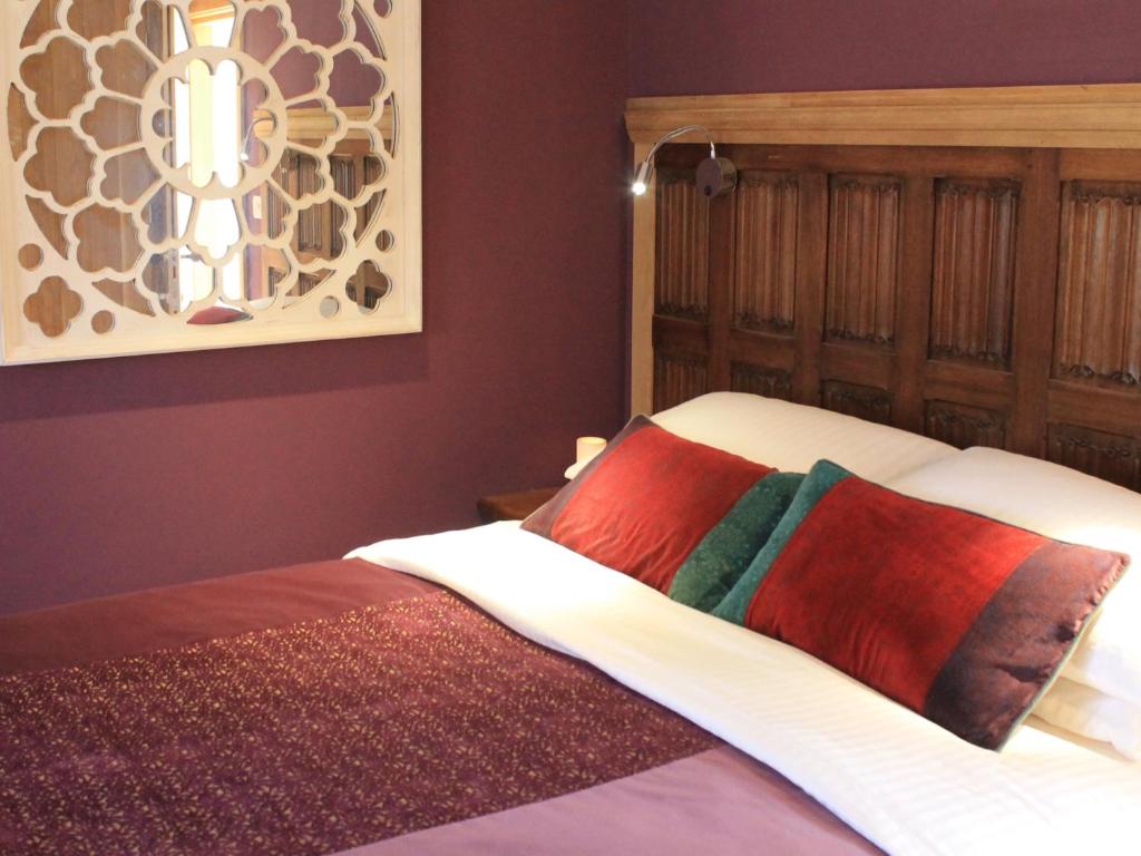 Hemingford GreyThe Lodge at Hemingford Grey House的一间卧室配有带色彩缤纷枕头的床。