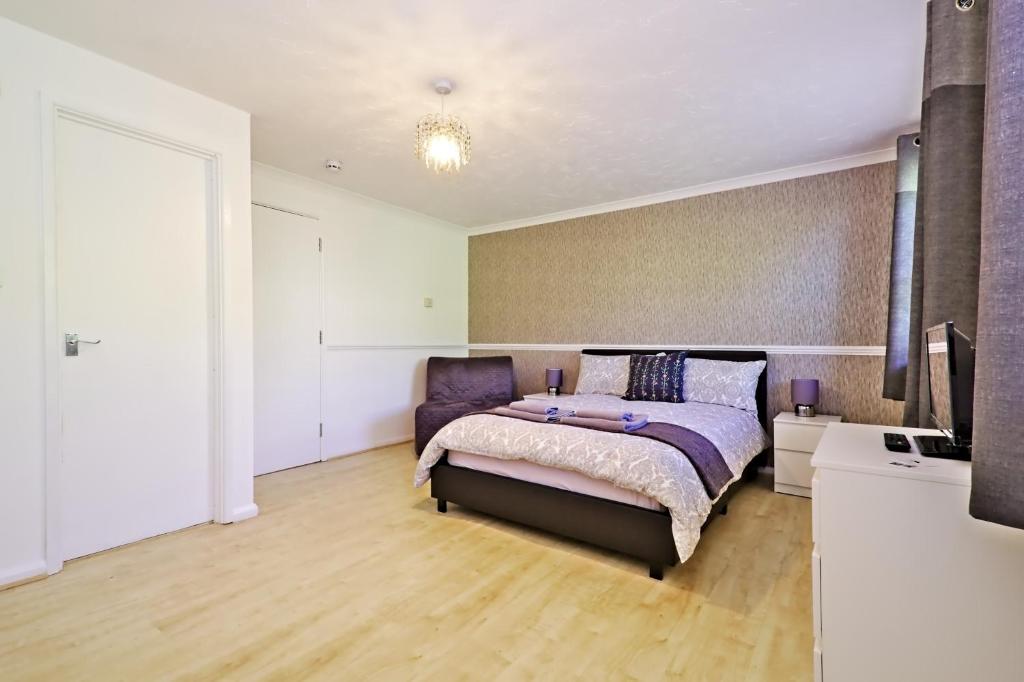 伦敦Harlinger Lodge Annexe的一间卧室配有一张床和一台电视。