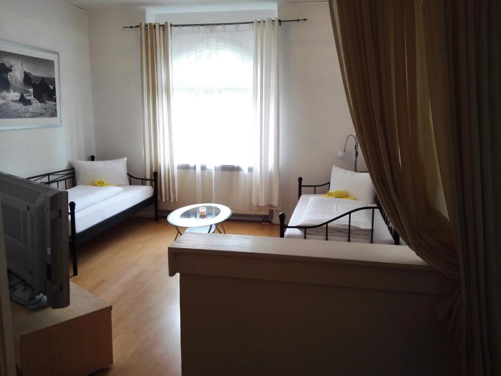 纽伦堡哈斯多夫尔公寓的一间带两张床和电视的客厅