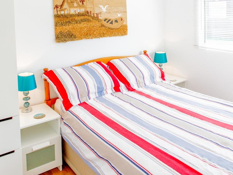 达特茅斯Hi-De-Hi Chalet 111的卧室里一张带条纹床罩的床