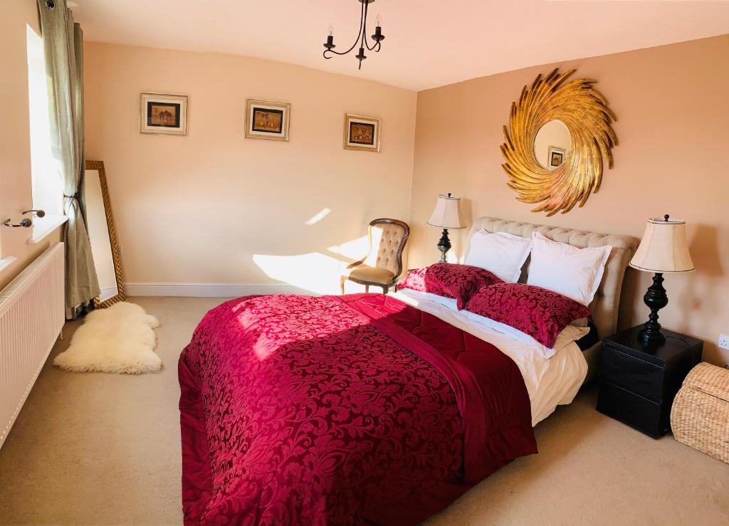 埃普沃思Holiday Home Epworth的一间卧室配有一张带红色被子和椅子的床