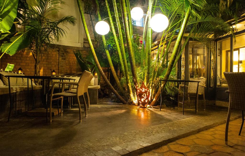 塔那那利佛拉里保迪耶里餐厅酒店的一间设有桌椅和植物的餐厅