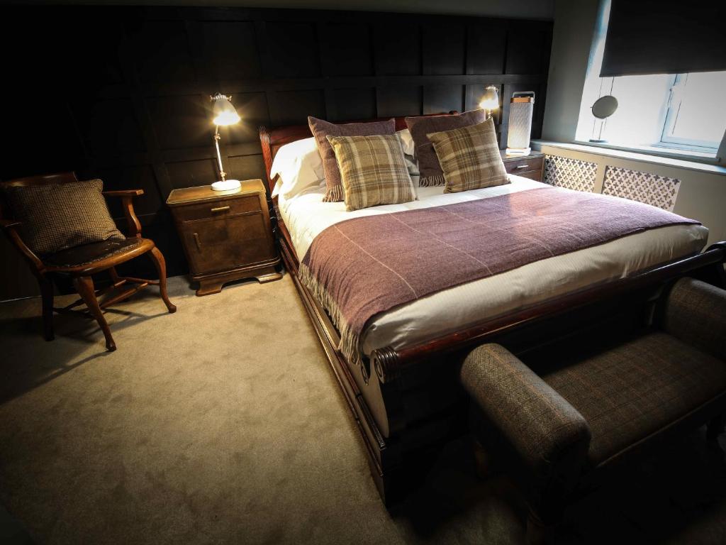 比斯特The Plough Bicester的一间卧室配有一张床、一把椅子和一盏灯