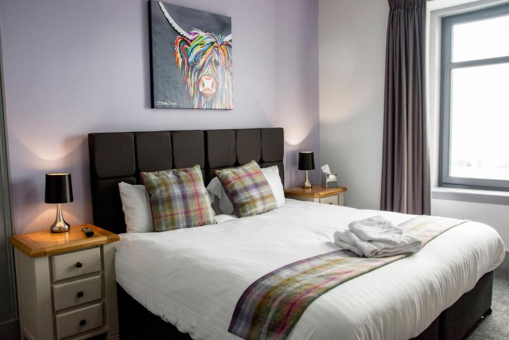 MacduffThe Knowes Hotel & Restaurant的一间卧室配有一张带两盏灯的大型白色床。