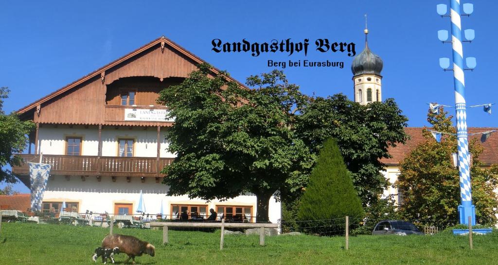 EurasburgLandgasthof Berg的前面有一棵树的大建筑