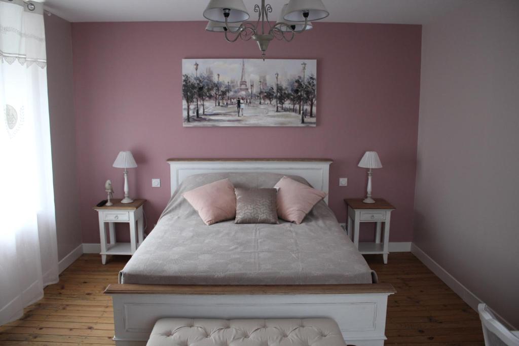 MardeuilLA PART DES ANGES的一间卧室配有一张粉红色墙壁的床和两张桌子