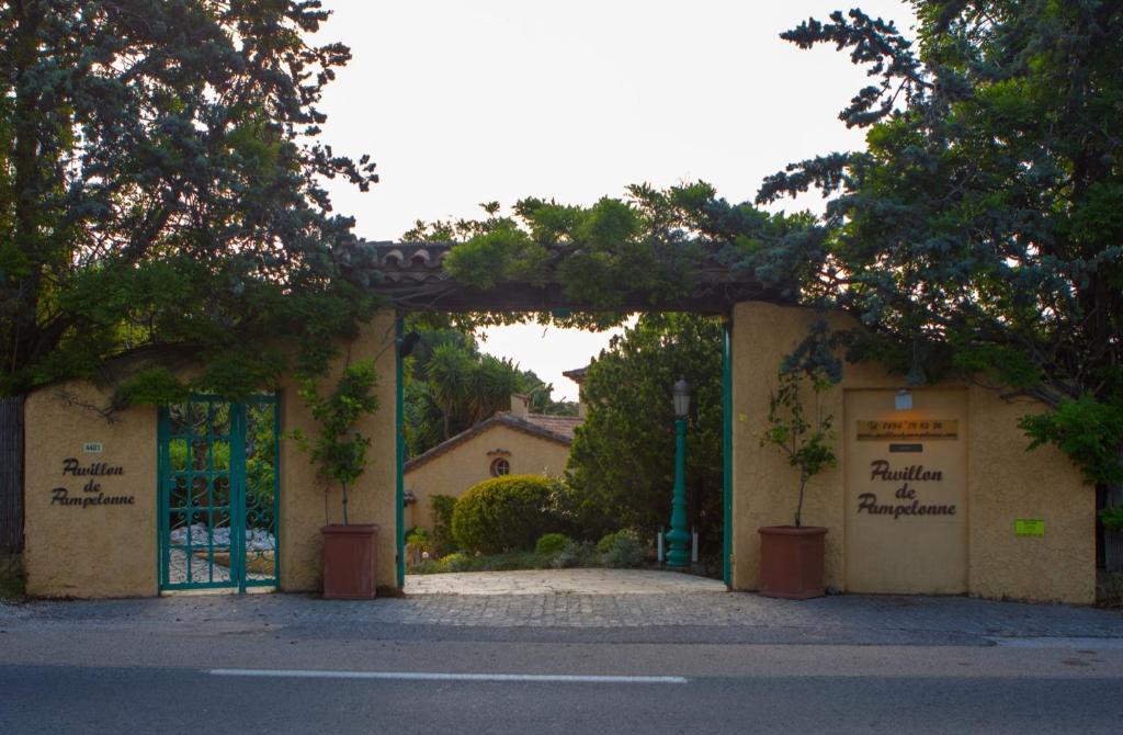 圣特罗佩圣廷苑德庞普洛纳旅馆的一座有门和树木的建筑的入口