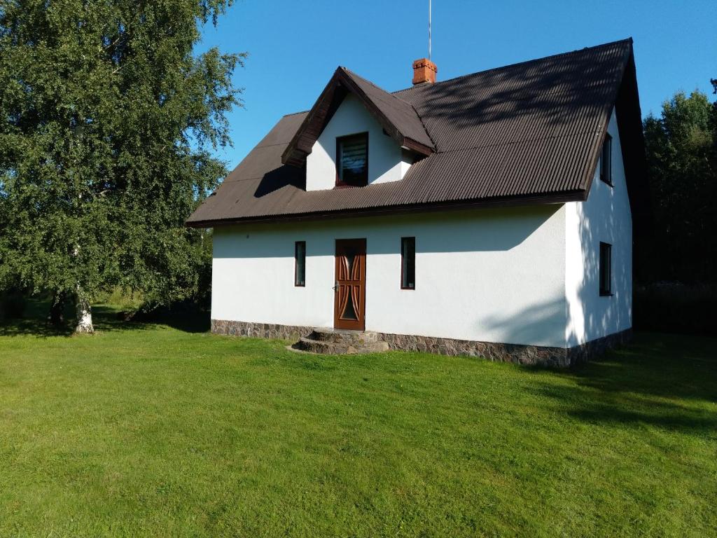 VecmuižaViesu nams Purenes的白色房子,有棕色的屋顶