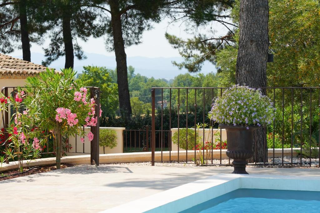 普罗旺斯艾克斯Cottage Aixois的铁栅,游泳池旁有盆栽