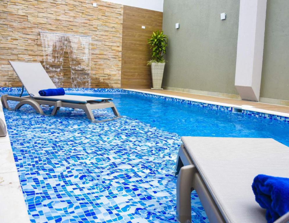 卡塔赫纳巴洛文托酒店的一个带椅子的游泳池和一个游泳池