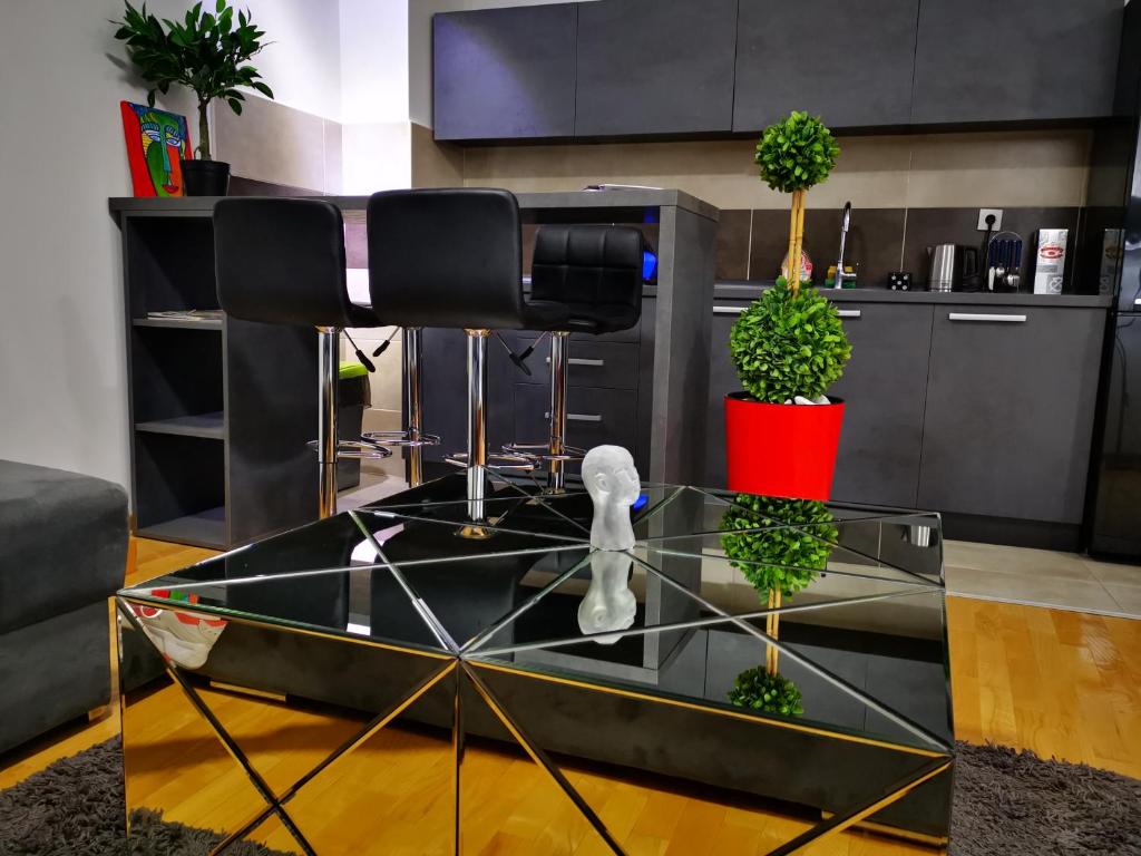 尼什Merkur Luxury Apartman的玻璃桌,上面有两株盆栽植物