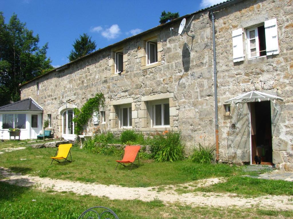 Saint-André-en-Vivarais乐派切德帕赛旅馆的一座石头房子前面有三把椅子