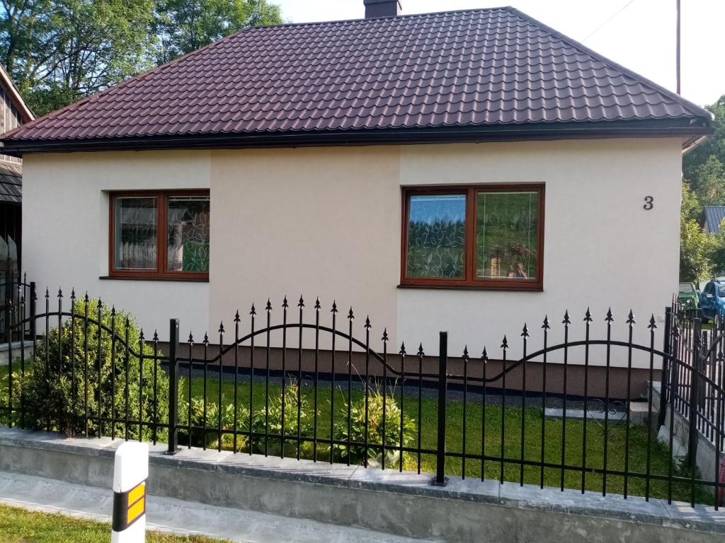 ReľovDomek的白色房子前面的黑色围栏