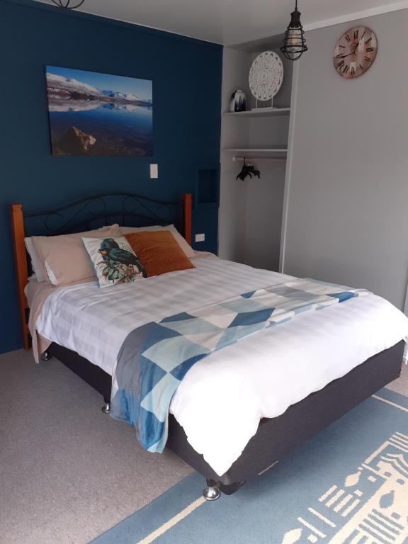 凯里凯里J&D Cottage的一间卧室配有一张带蓝色墙壁的大床