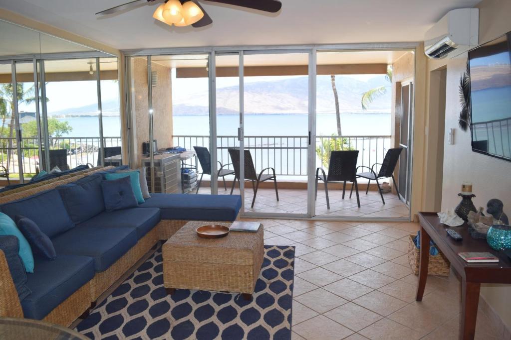 基黑Menehune Shores 309的客厅配有蓝色沙发,享有海景
