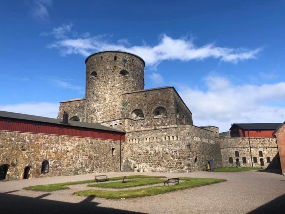 马斯特兰德索尔达藤斯住宿加早餐旅馆的一座大型石头建筑,前面有两长椅