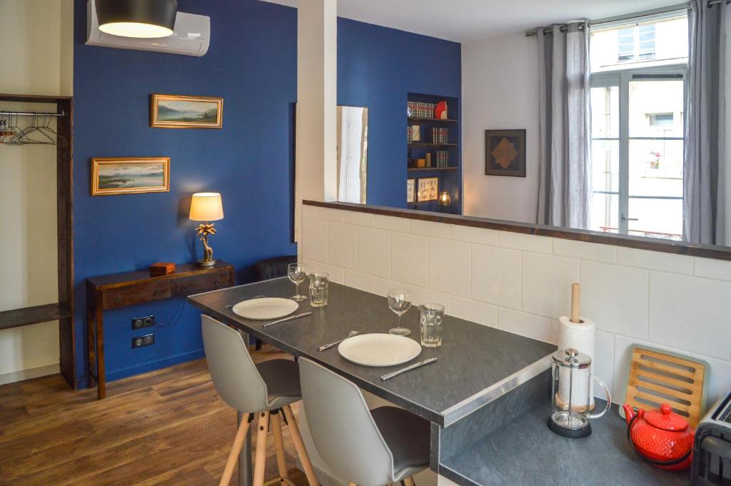 贝尔热拉克莱斯都宫公寓的一间带桌椅和镜子的用餐室